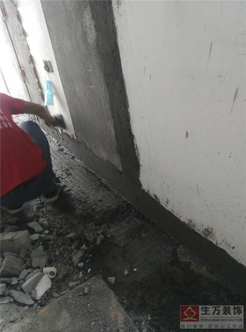 精装修泥工工程师修补主人房的线槽。